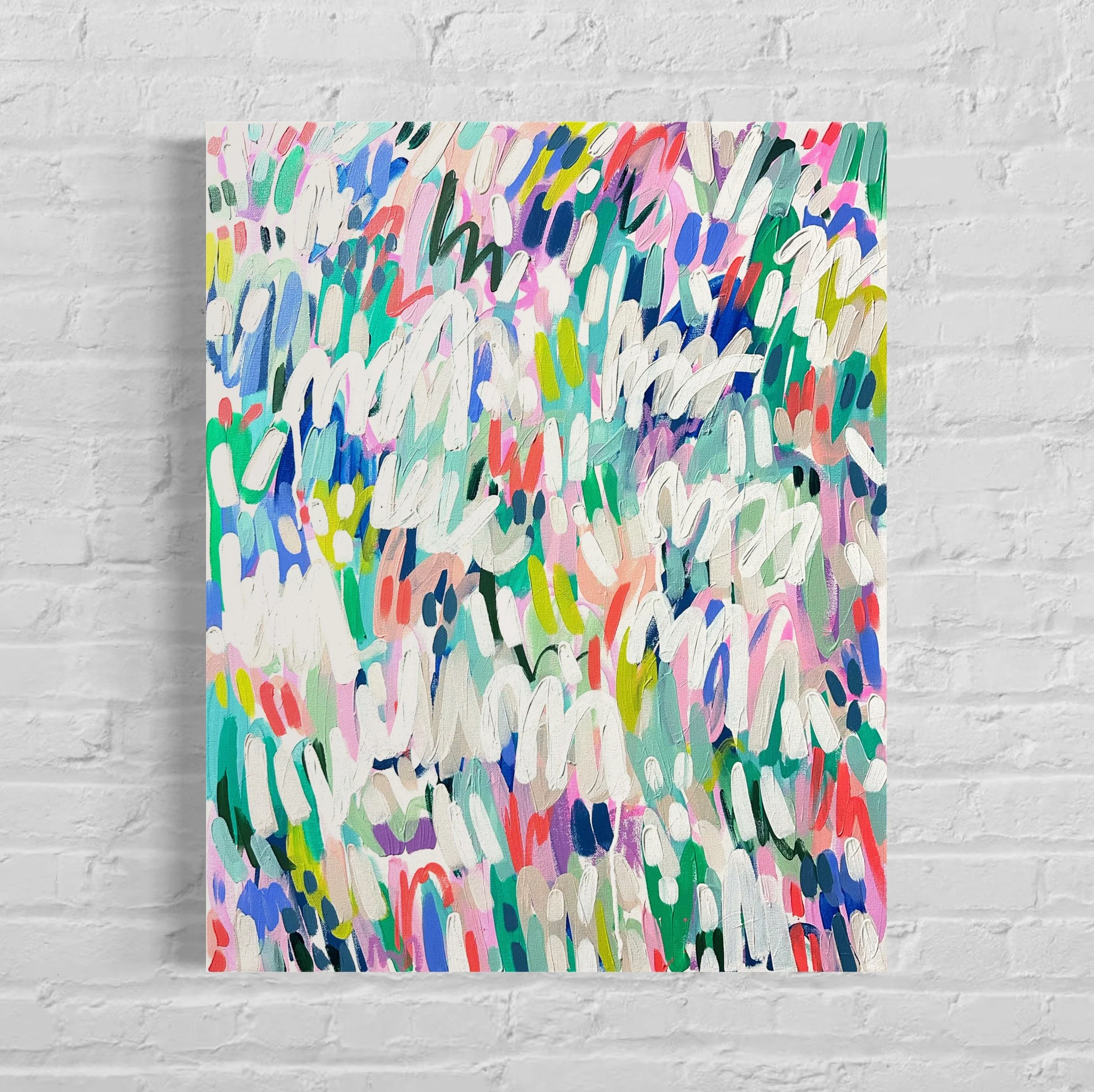 An abstract painting with colorful brushstrokes on a rectangular canvas, mounted on a white brick wall.