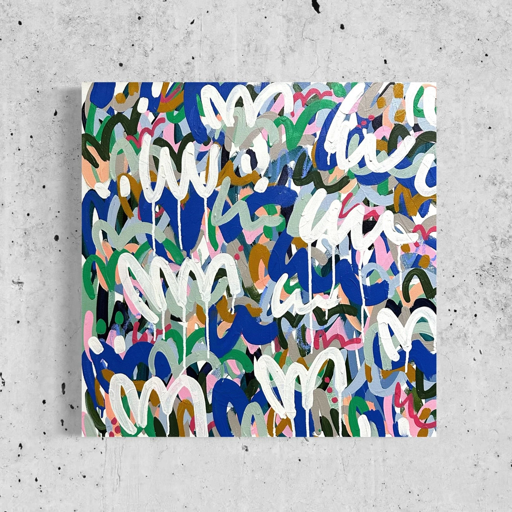 Colorful abstract painting with squiggly lines and shapes on a mixed media background of concrete and a painted canvas.
