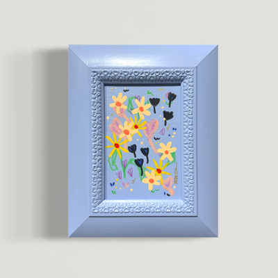 Framed colorful spring-themed artwork with yellow flowers, pink rabbits, black hearts, and butterflies
