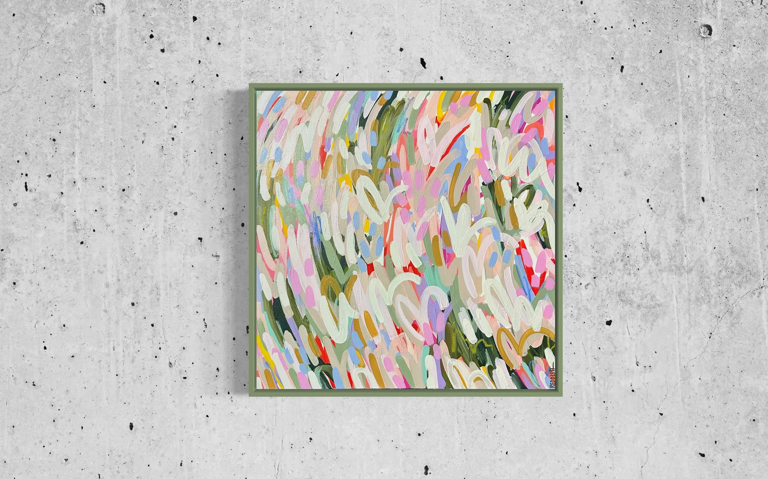 Colorful abstract painting with swirling brushstrokes in various pastel and bold colors, framed and hung on a concrete wall.