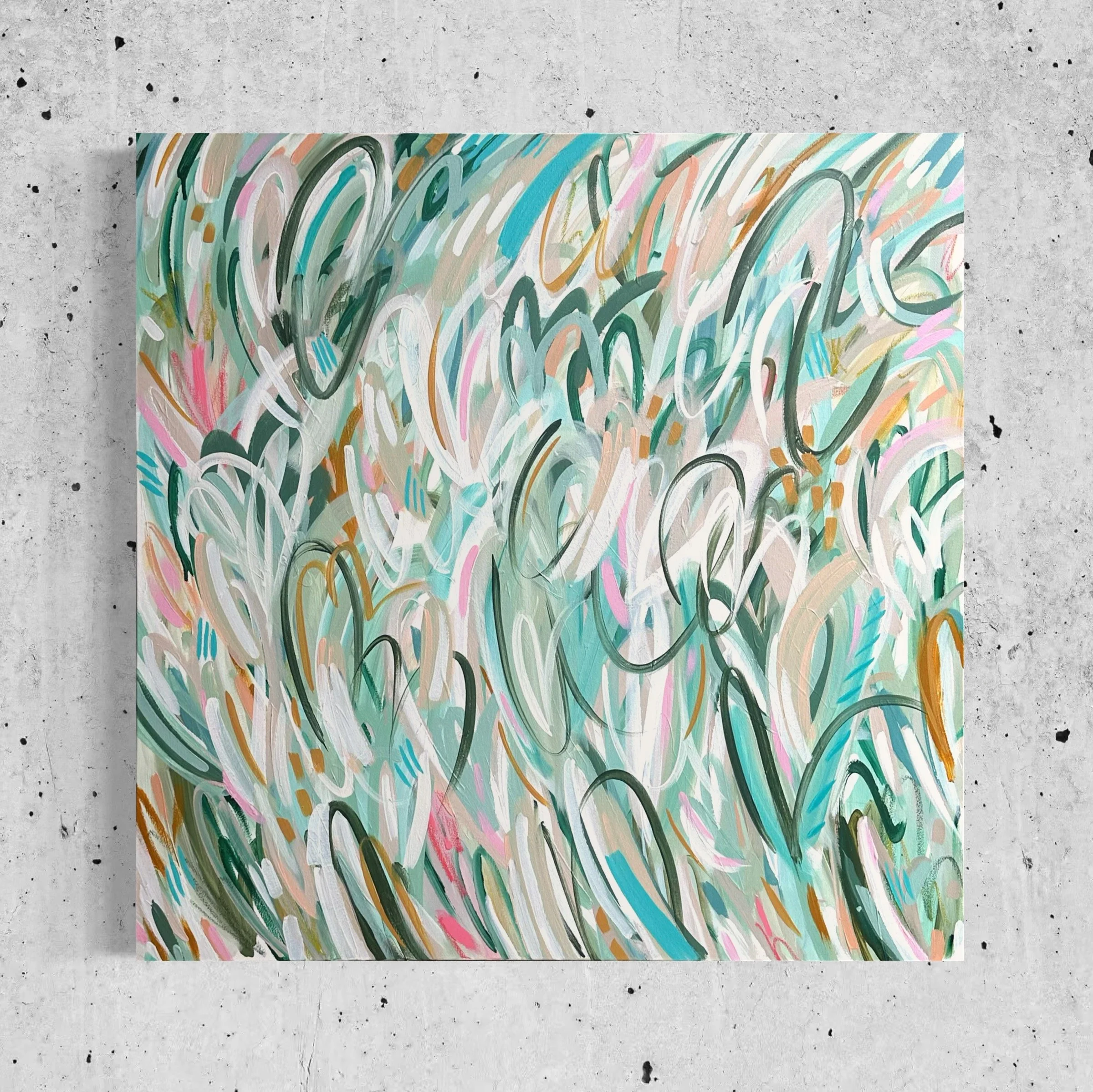 An abstract painting with colorful swirling lines on a rectangular canvas placed on a concrete surface.