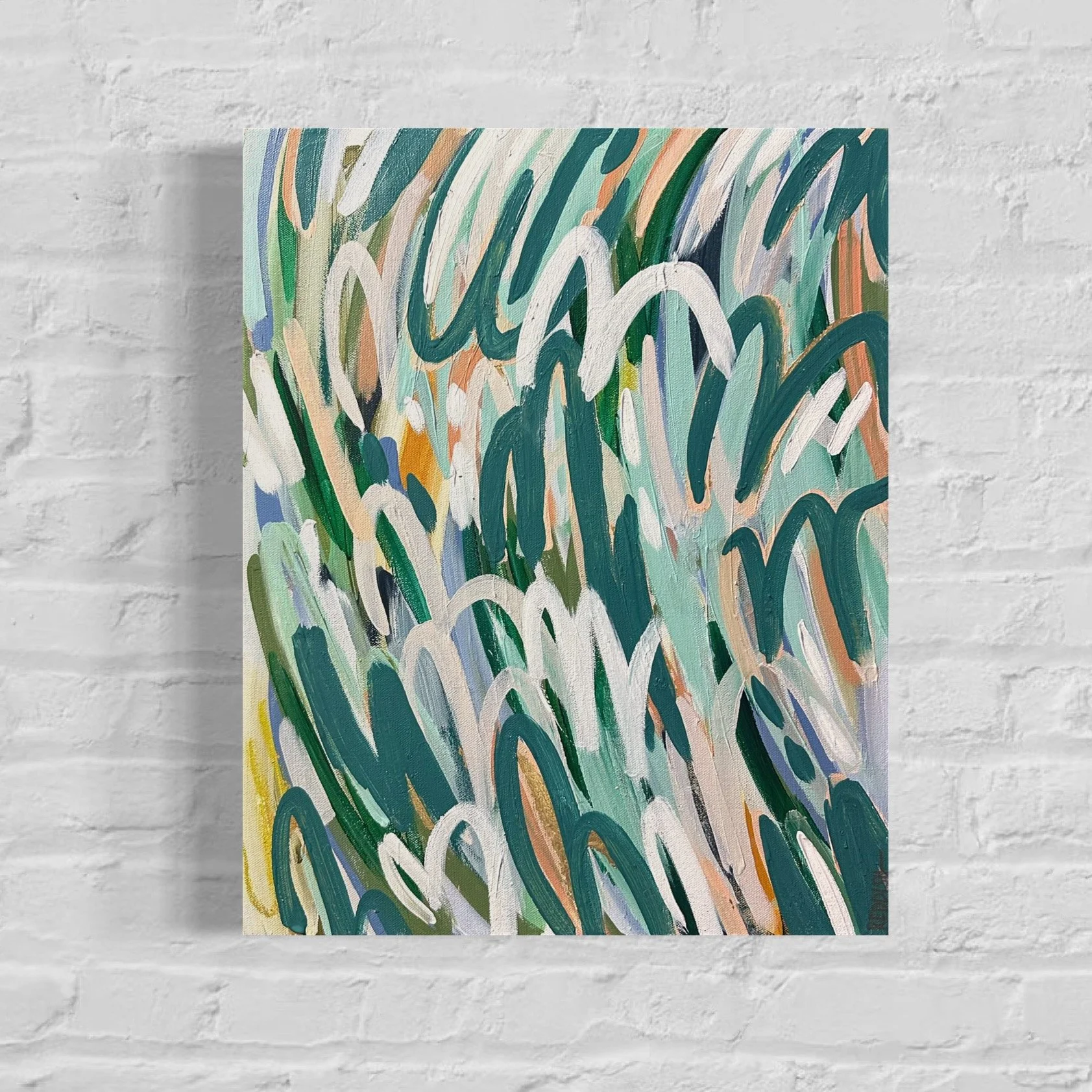 Close-up view of an abstract acrylic painting with bold, curved brushstrokes in green, white, orange, blue, and yellow colors, mounted on a white brick wall.