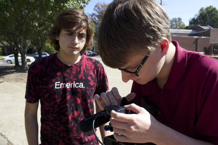 Supervising videographer Matt Sloan works with videographer Daniel Jaramillo to fix an audio issue.