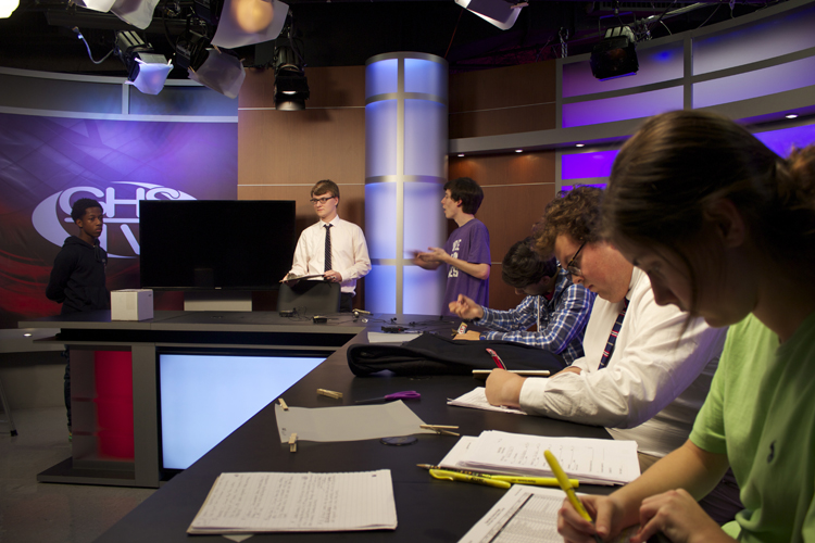  In the background, supervising videographer Matt Sloan (who was a student anchor producer in '08 and student director in '10) speaks with the audio crew about changes to this year's microphone process. 