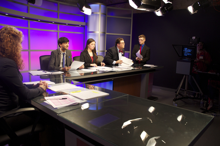 Will Alton waits for an open seat on the anchor desk.