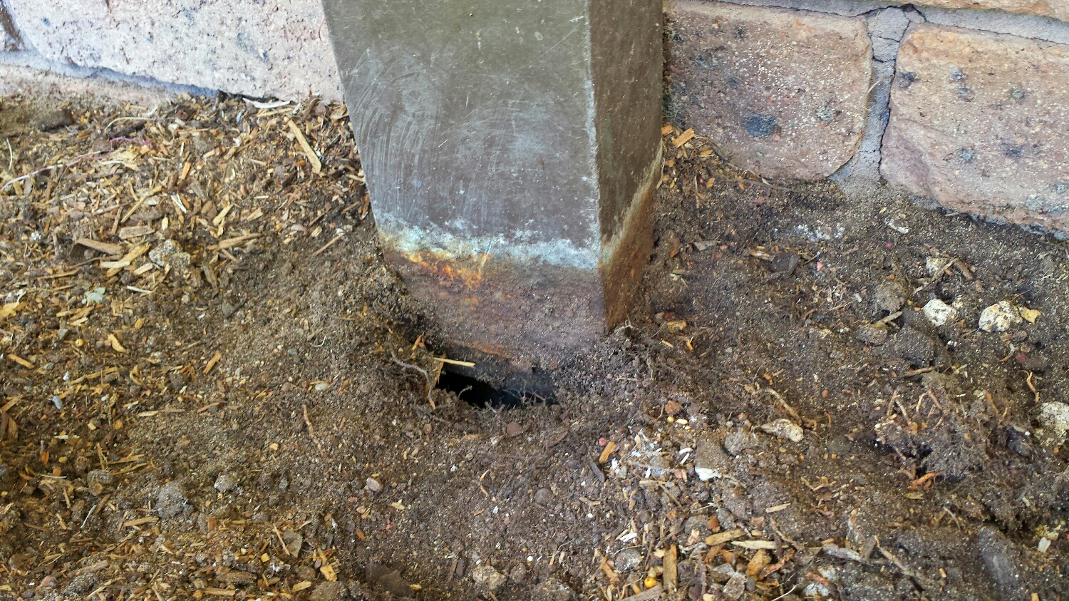 This downpipe appeared sound, until digging around it revealed that it was rusted and allowing water to drain against the building. This was discovered during a termit inspection.