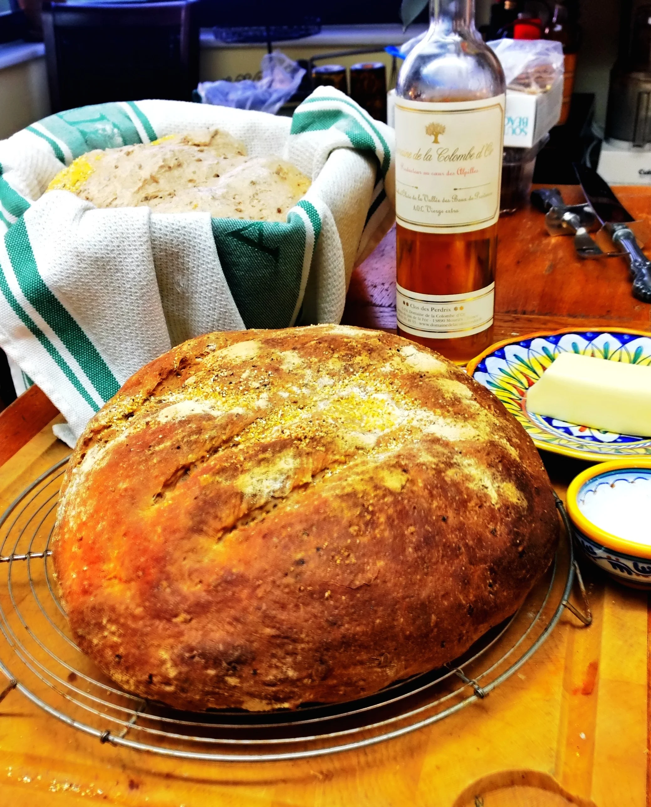 My spent grain loaf, baked in the foreground an a risen loaf about to be put on the baking stone in the background, with the best accompaniments: salt, butter and olive oil