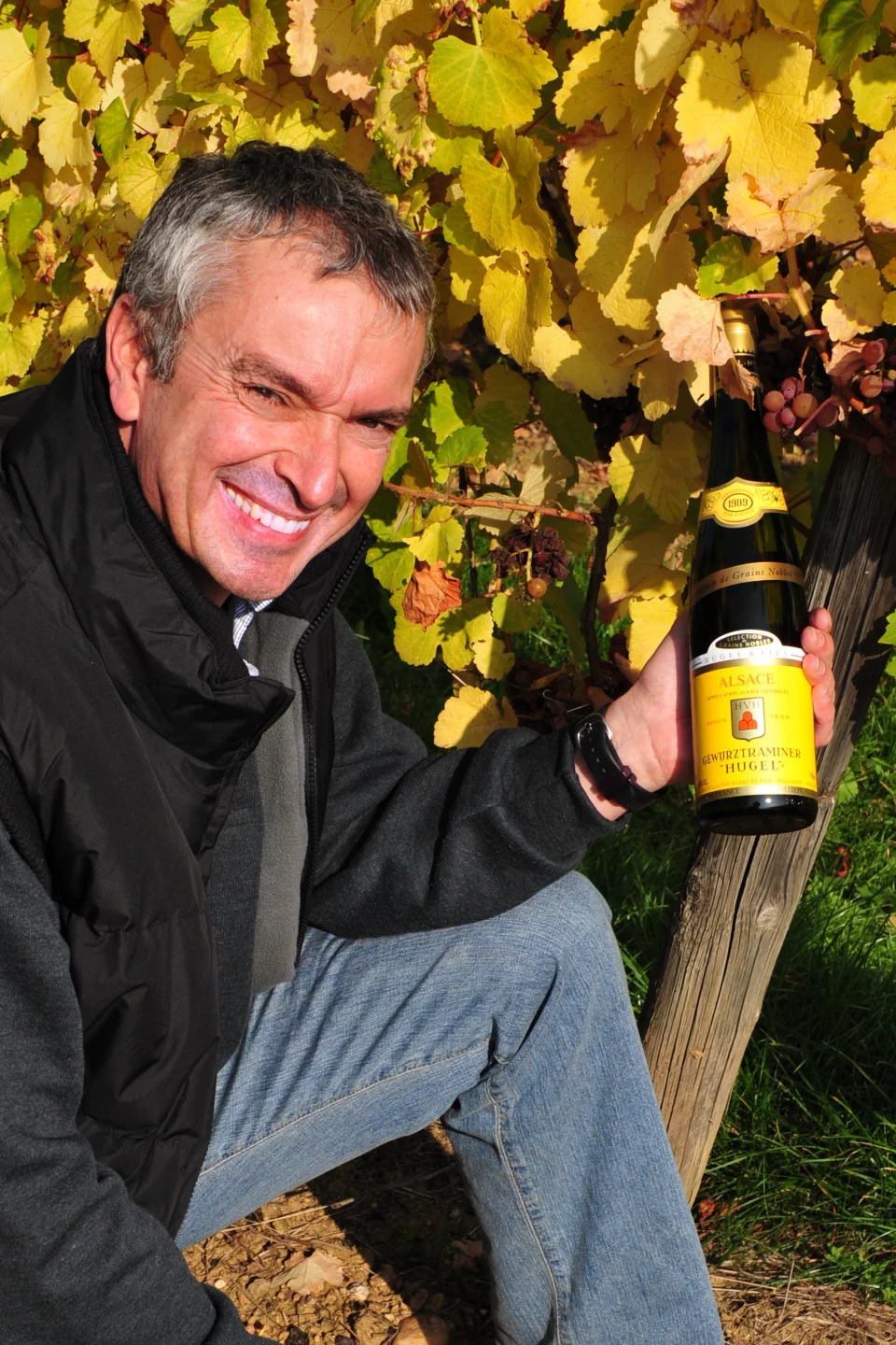 Etienne Hugel in the vineyard at the end of harvest with a bottle of gewurztraminer (Photo: Hugel)