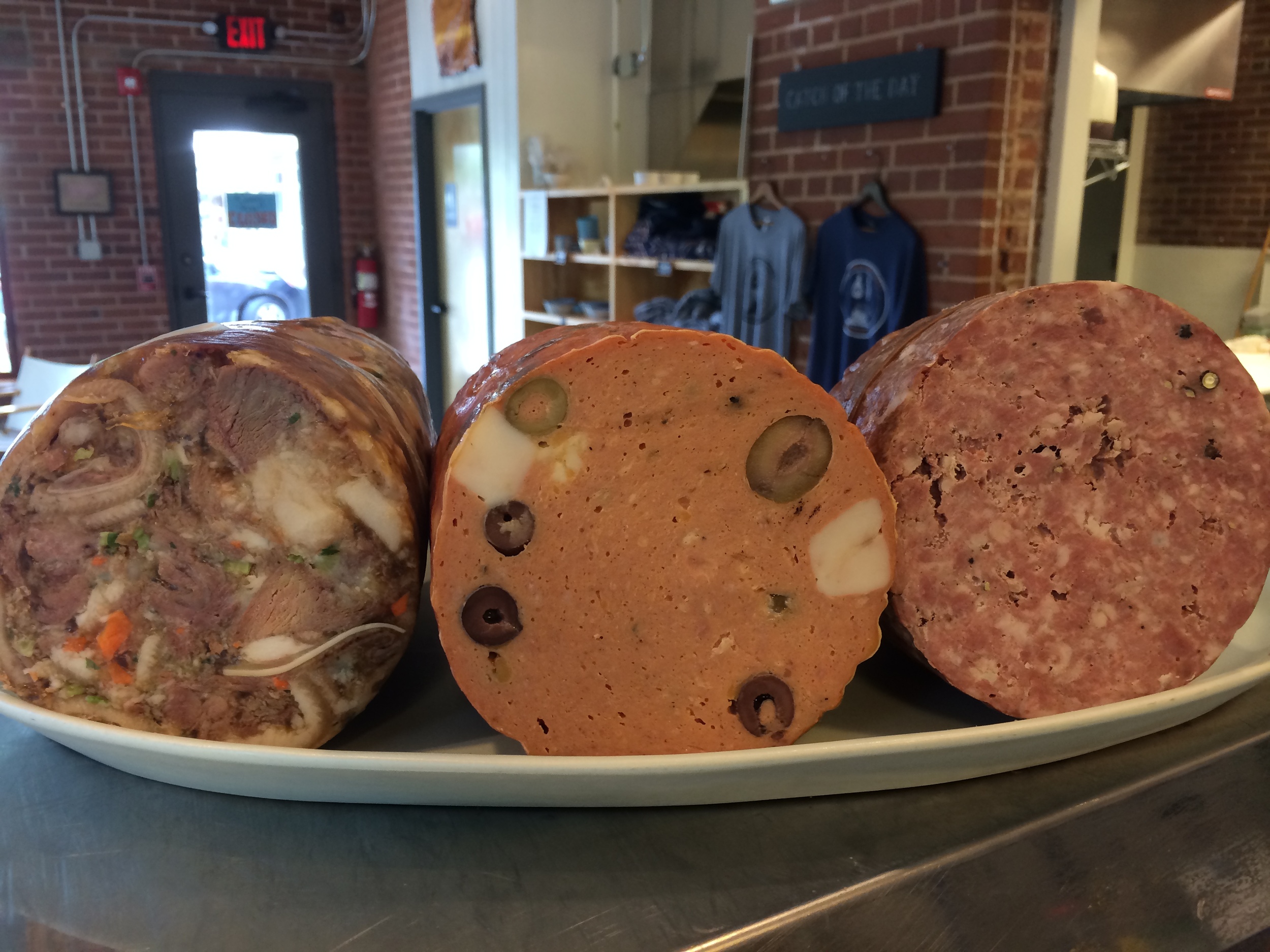From left to right, we have head cheese - a delicious European delicacy that is essentially a terrine made from the tasty parts like cheeks and tongues, Mortadella, and Salami. All made in house, of course!