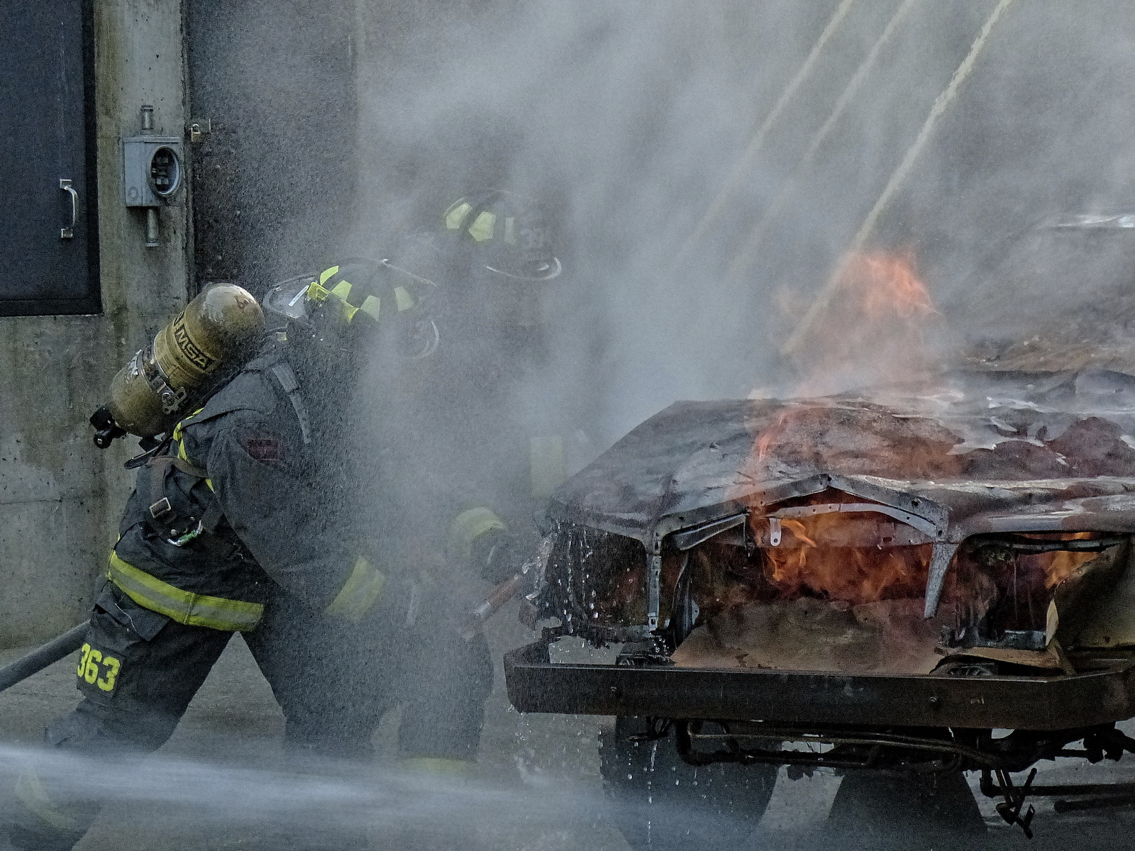 Prying open the hood of a car on fire