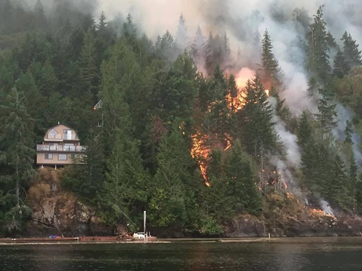 This photo shows the proximity of the fire to one of the homes the Comox Fire Department crew was called on to protect. — Image Credit: Photo Submitted