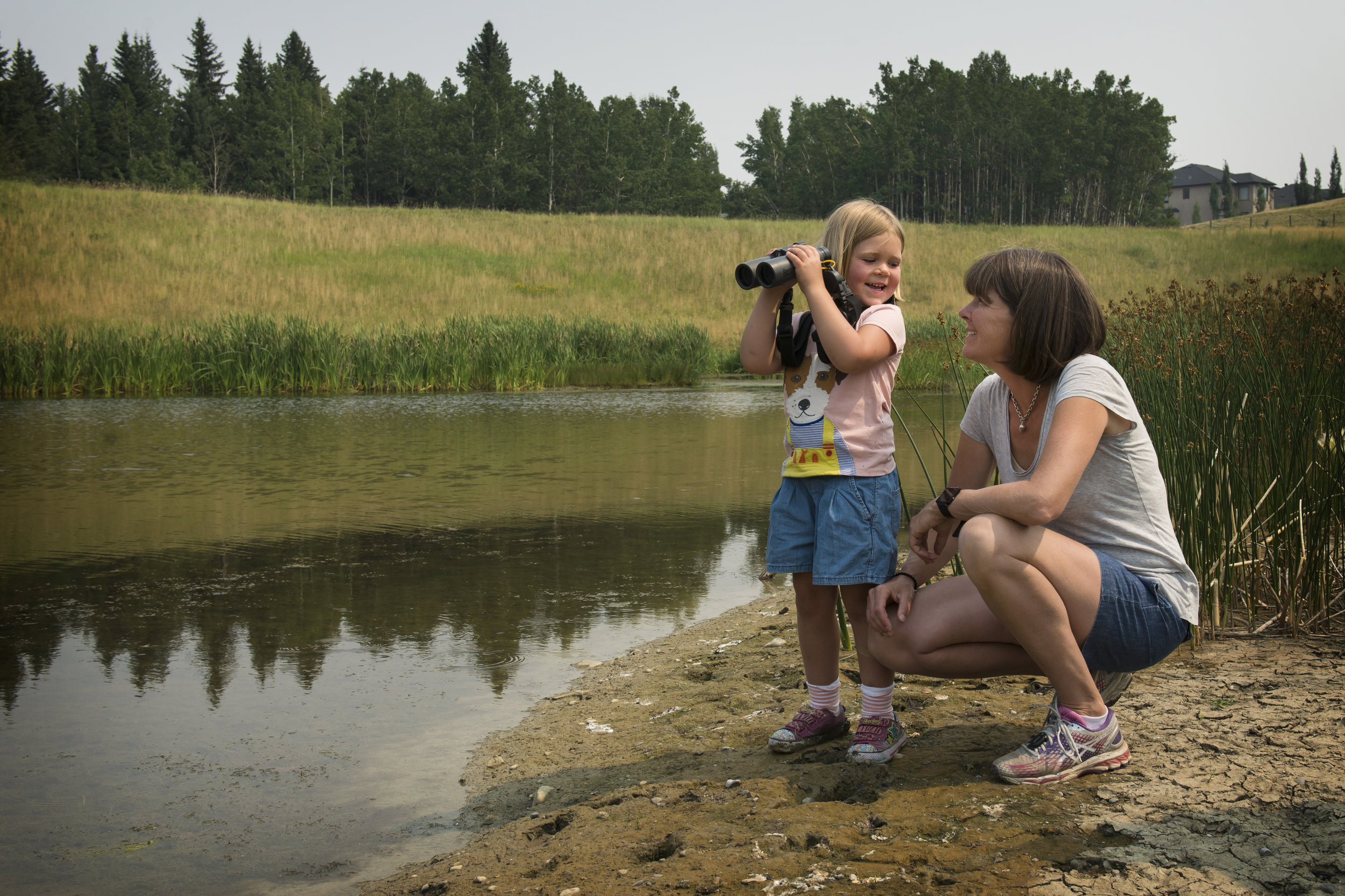 While visiting a local wetland with the Miistakis Institute, four-year-old Taylor watches the ducks with her mom.