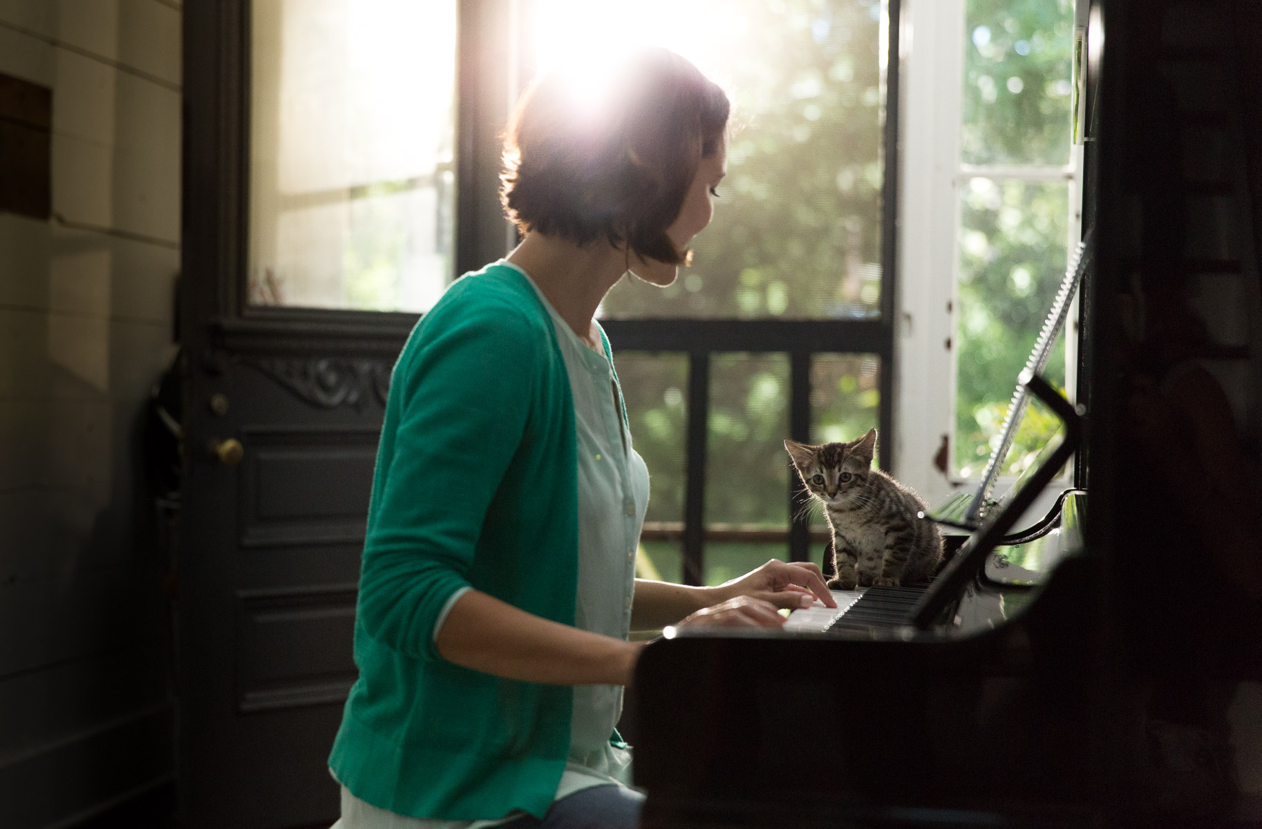 woman-playing-piano-with-cat-on-keyboards-pet-photography.jpg