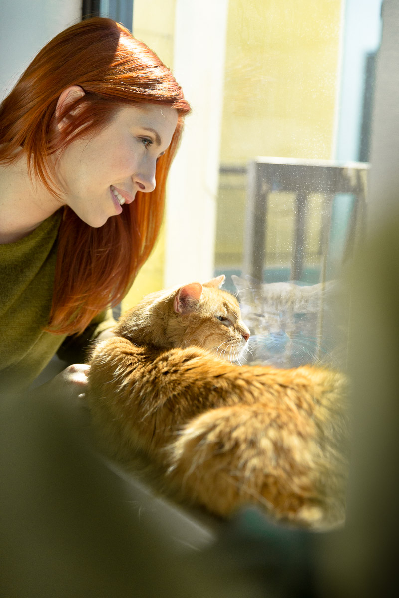 woman-with-cat-looking-out-window-apartment-cat-photographer.jpg