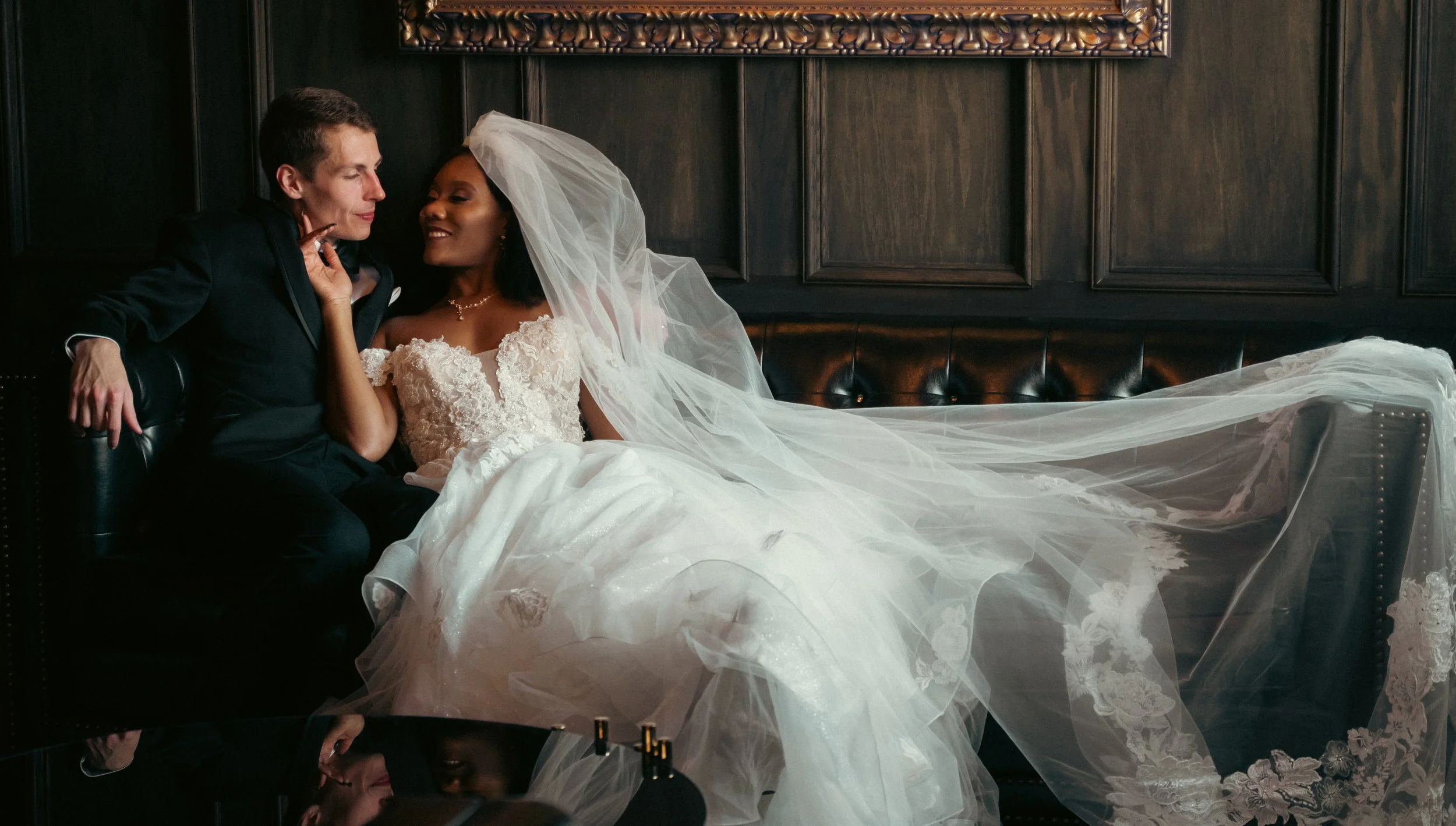 Bride and groom holding hands, walking past the bridal party as they hold up lightsabers during their wedding In Ann Arbor area.