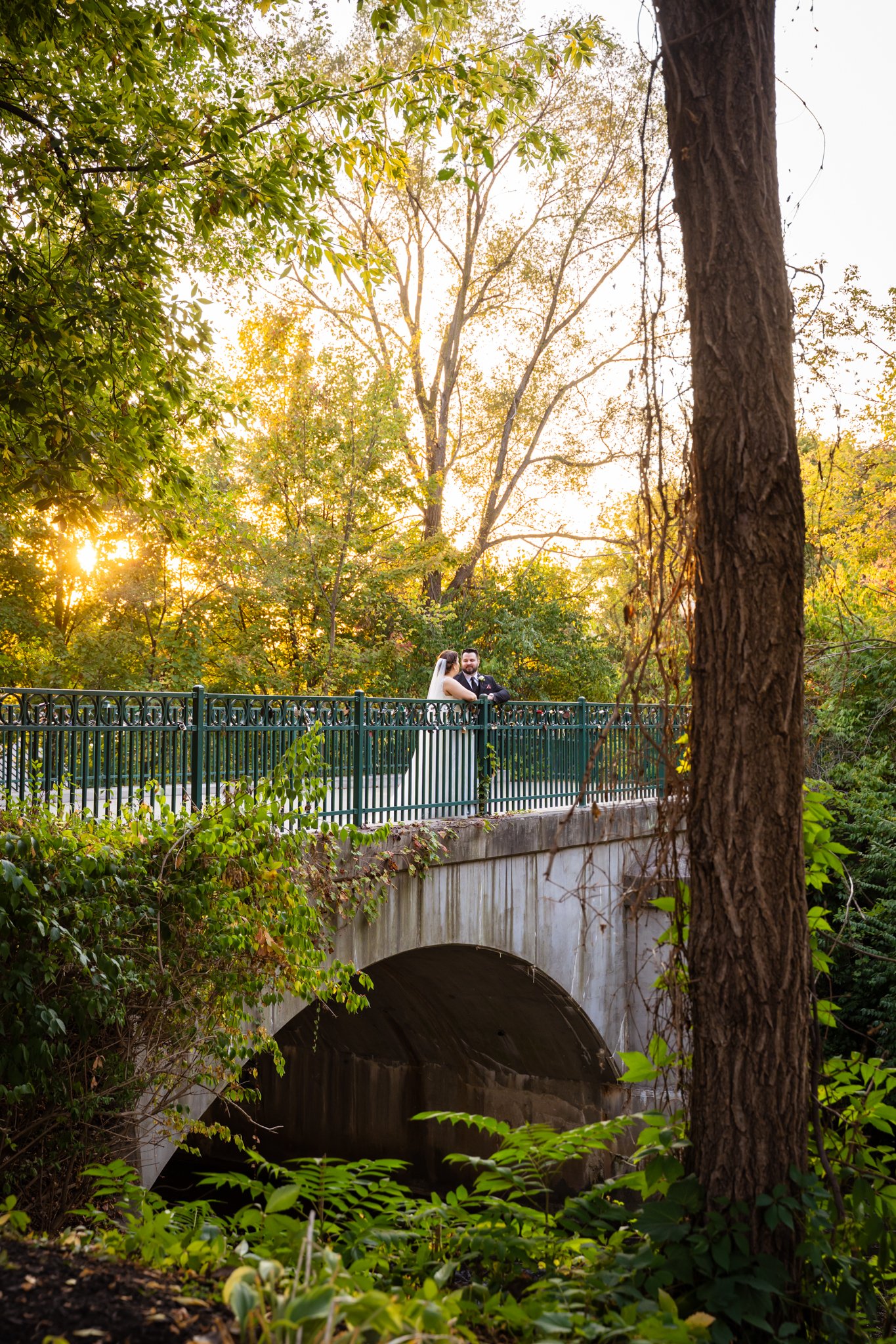 A bride and groom holding hands outdoors on their wedding day, captured by a wedding photographer in Michigan.