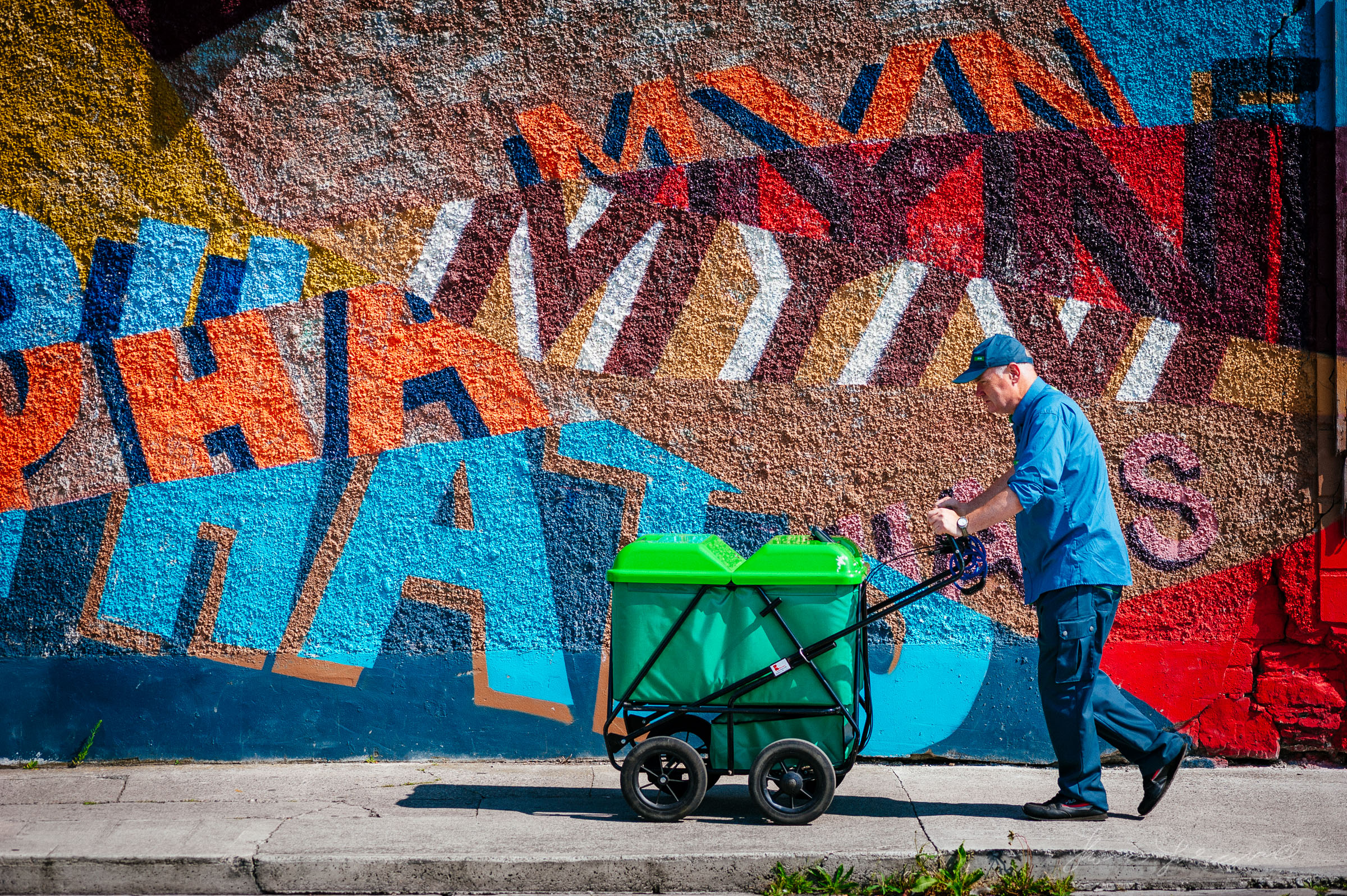 Postman walking against a grafitti covered wall