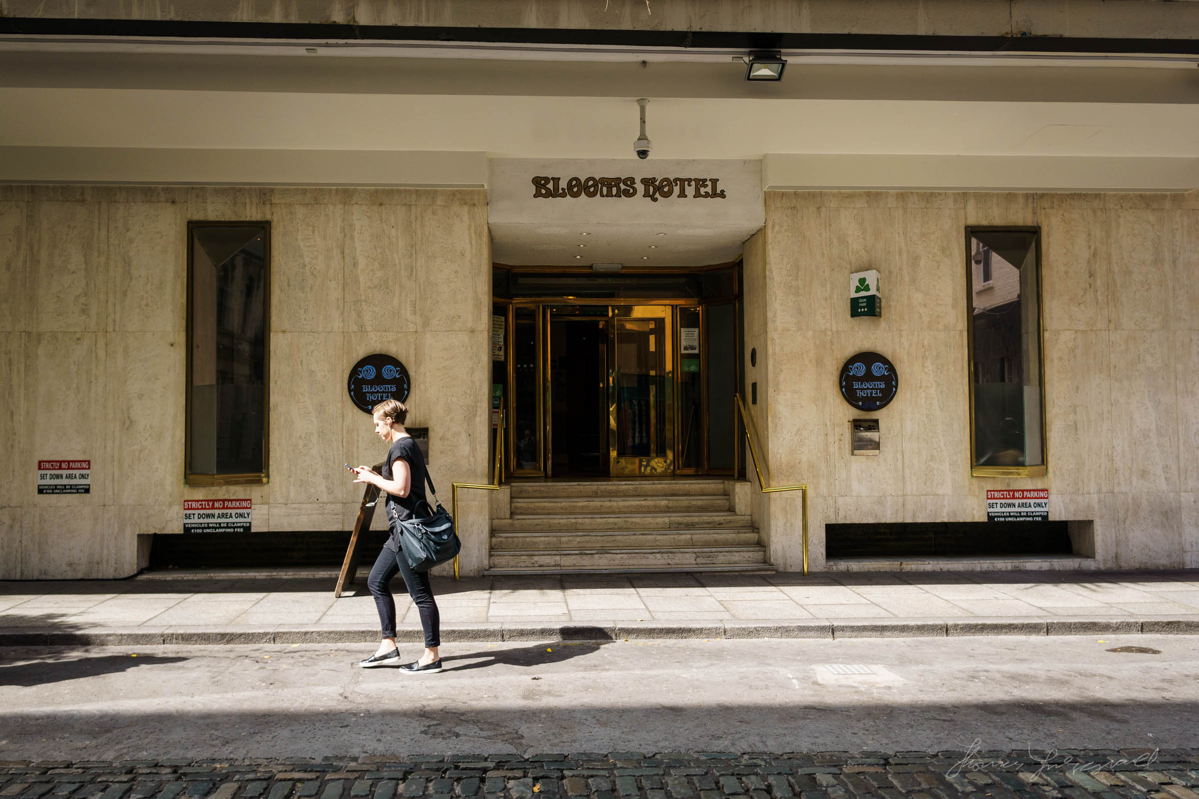 A person Walks by the Blooms Hotel in Dublin