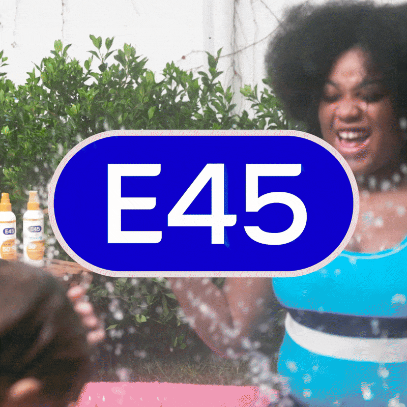 Woman doing a cheers to camera, while feeling confident. Children as splashing around near here and subtitles of 'this is me in Costa del Croydon' appear on the screen. We see e45 sun products on screen.