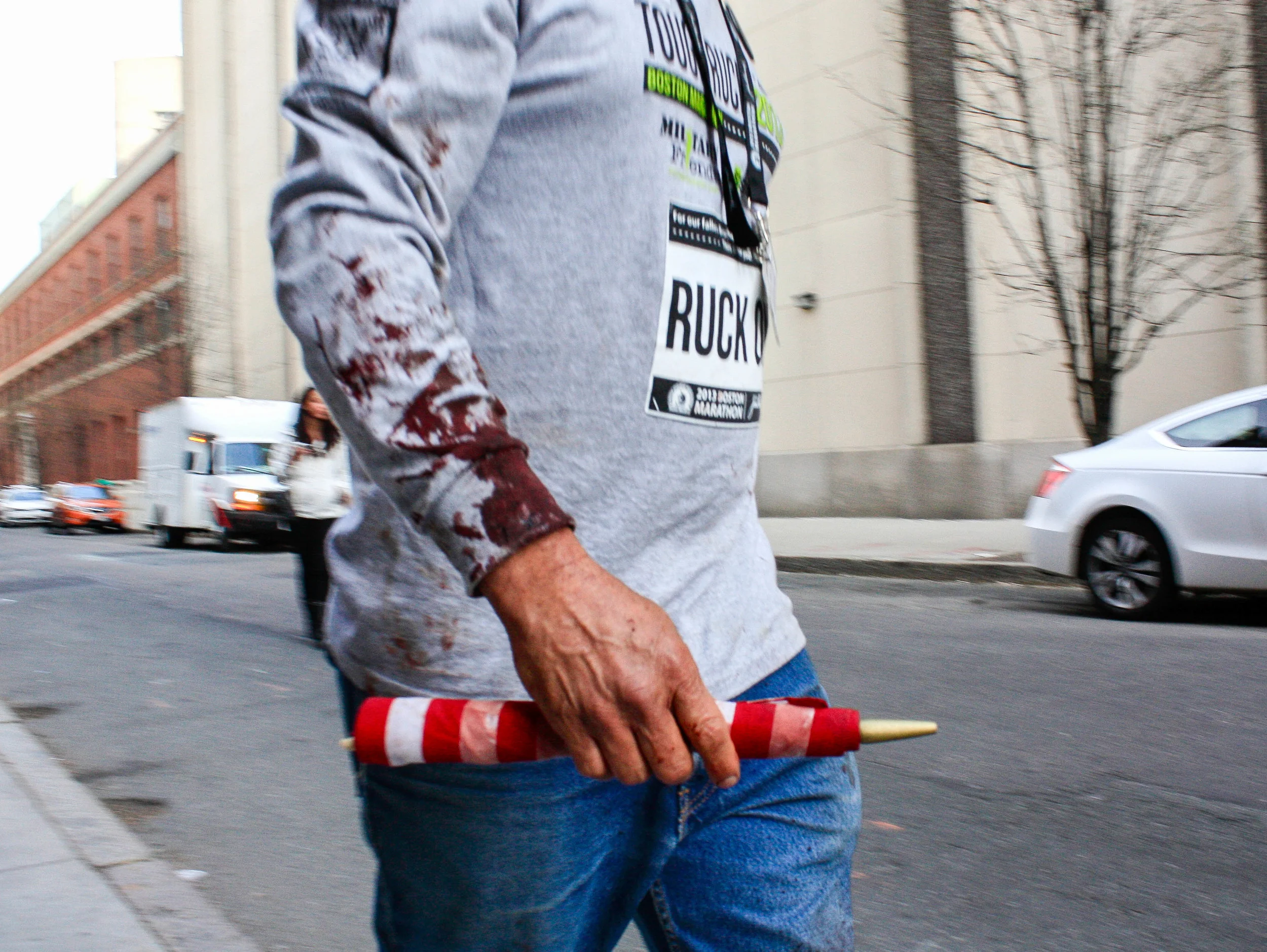 Carlos Arredondo holds a bloody American flag as he walks near Boylston Street after the Boston Marathon bombings in Boston, Massachusetts. After the first bomb exploded at the Boston Marathon, Arredono ran to the explosion to help those who were hurt. He helped save the life of Jeff Bauman, who lost both of his legs during the explosion.