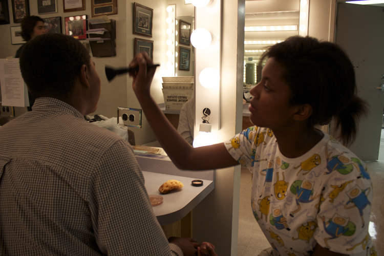  Make-up crew member Naya Foster helps Kennedy Harris get into character before the show. 