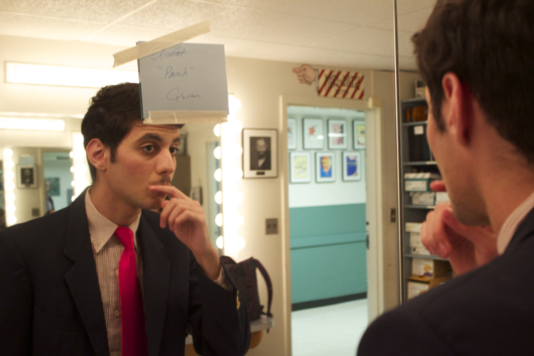 Arafat Quran checks out his mustache before taking the stage as vice principal Douglas Panch.