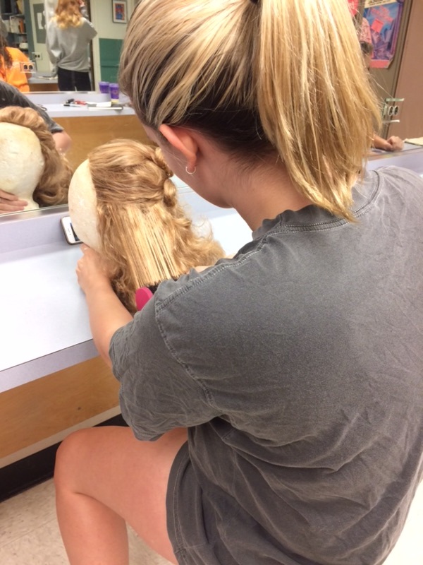 Makeup Co-Chairman Meredith Drown prepares a wig to be styled