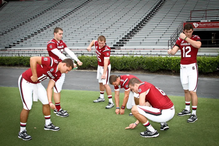 The team's quarterbacks do a little bit of lawn care at Williams-Brice.