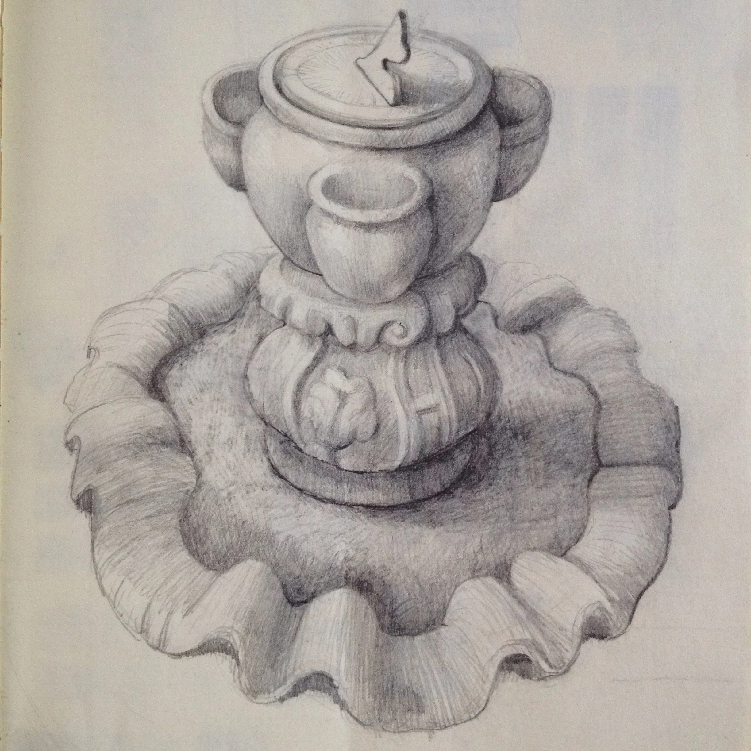 A piece of an old fountain holds a planter and sundial