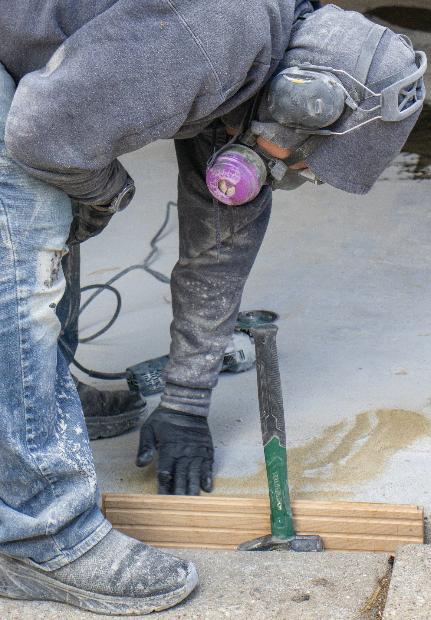 Kevin prepping garage floor with sand to fill cracks