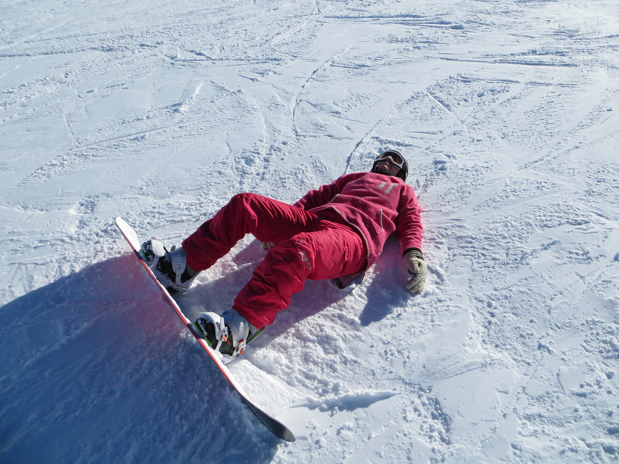Kate trying to learn to snowboard- caught the heel-edge, fell downhill hitting tailbone and back of head hard on the packed snow...