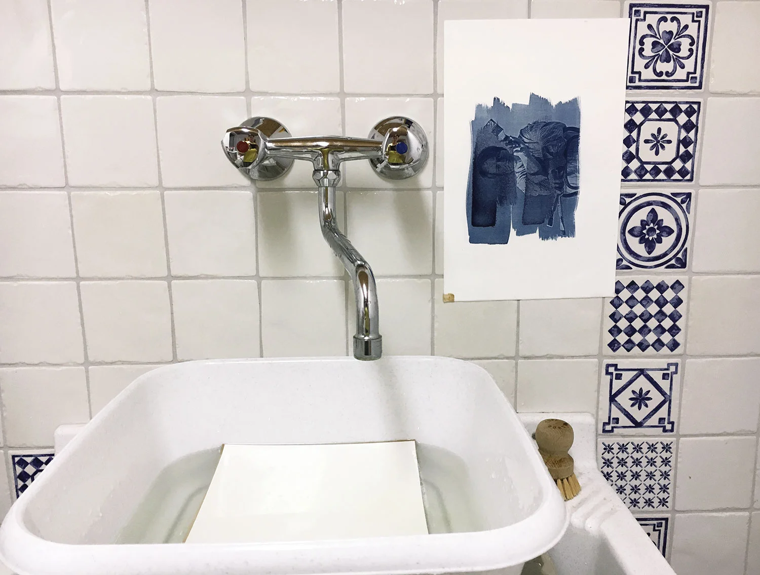 Während das erste Papier kurz an der Wand abtropft, lege ich das nächste mit dem Motiv nach unten ins Wasserbad.