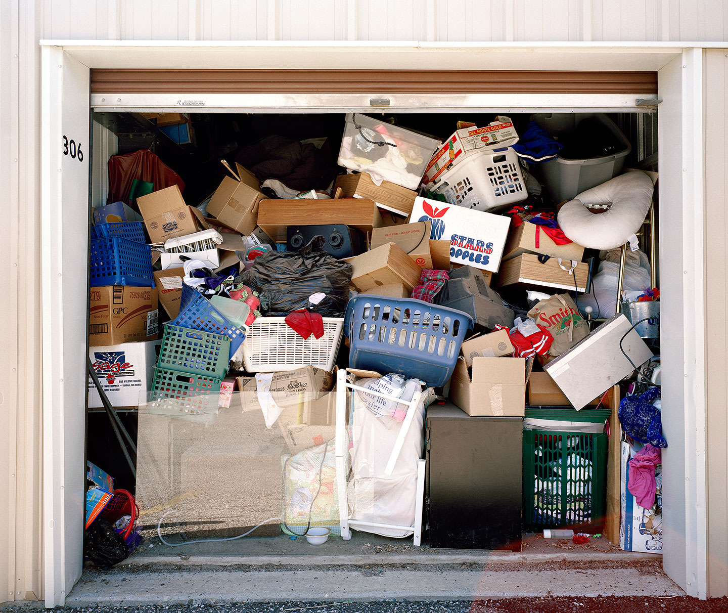 I documented storage units located in isolated places, on small roads, near airports, on strip mall outskirts. They feel distant from everyday society, yet when entering a unit the human desire for refuge, comfort, and safety is undeniably present, expressed in the way space is inhabited or altered.