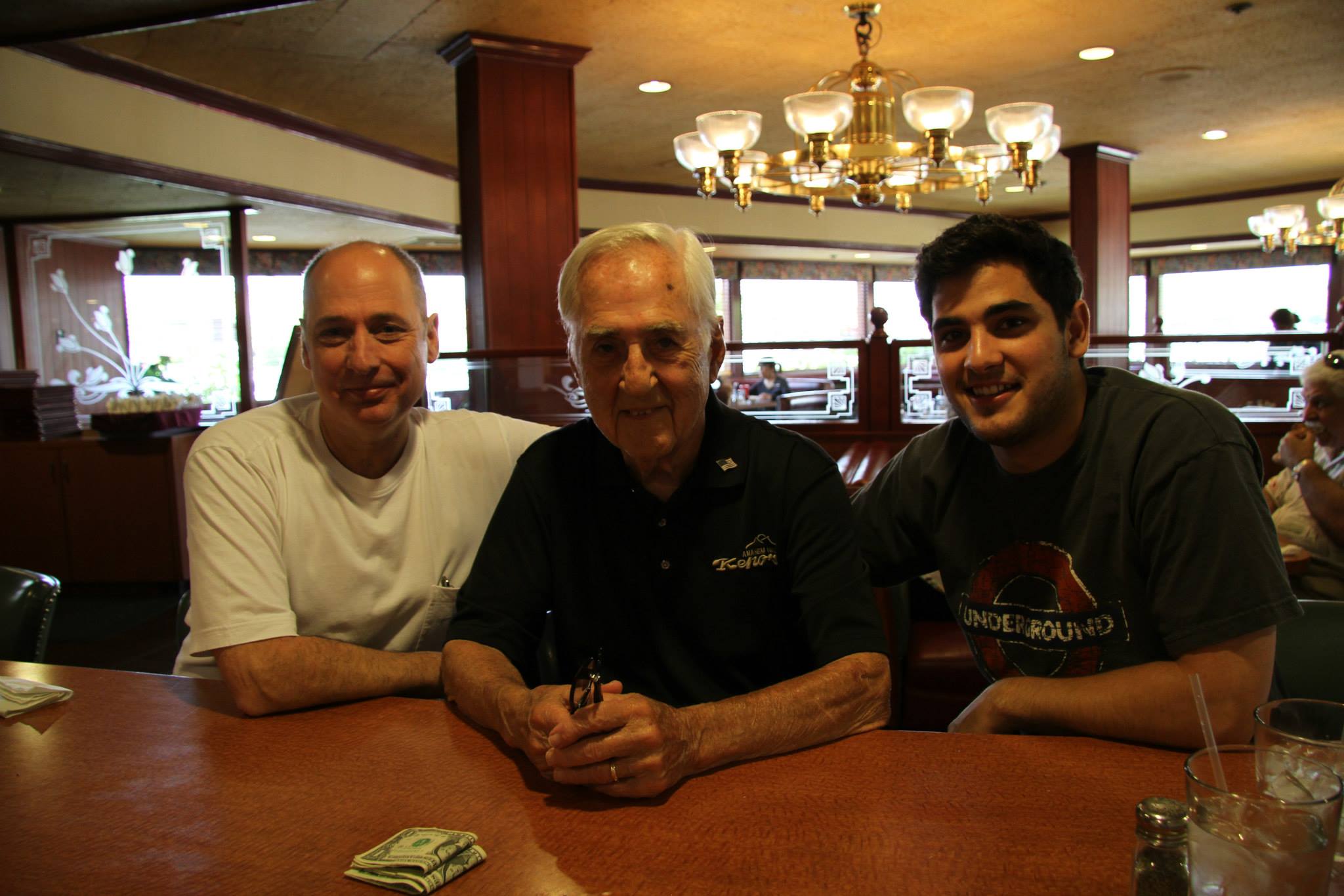 Three generations of Cooper men (Steve, Geno, Robert) pictured sitting on the Kenos counter.