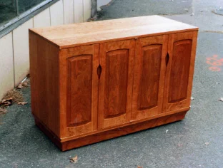 handmade hardwood cherry dovetail buffet with arched frame and panel doors and carved pulls