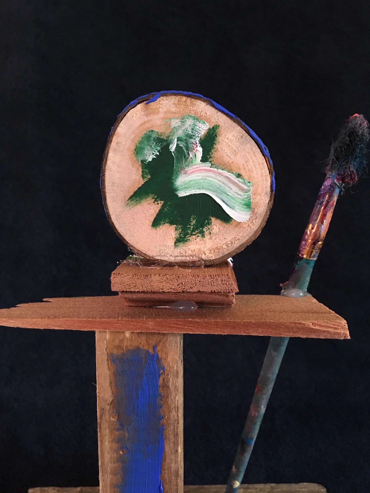 oil paint, paintbrush and wood sculpture on wooden base