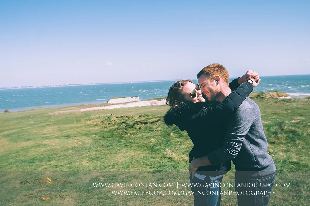 Victoria and James cuddling and smiling at Old Harry Rocks . Engagement Session in Bournemouth, Dorset by gavin conlan photography Ltd