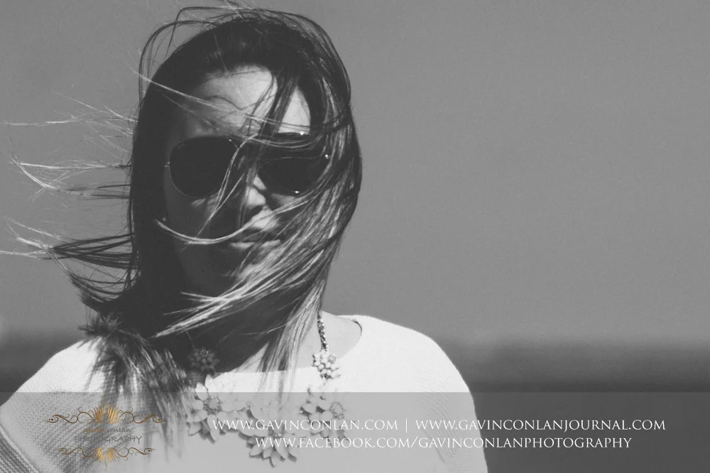 creative black and portrait of Victoria showing the wind blowing through her hair at Old Harry Rocks . Victoria and James Engagement Session in Bournemouth, Dorset by gavin conlan photography Ltd