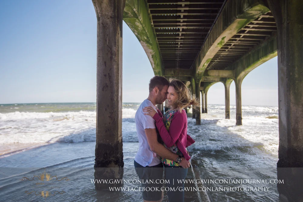 creative fashion portrait of Victoria and James underneath Boscombe Pier . Engagement Session in Bournemouth, Dorset by gavin conlan photography Ltd