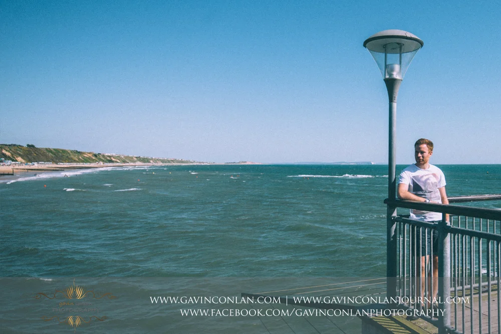 creative portrait of James on Boscombe Pier . Victoria and James Engagement Session in Bournemouth, Dorset by gavin conlan photography Ltd