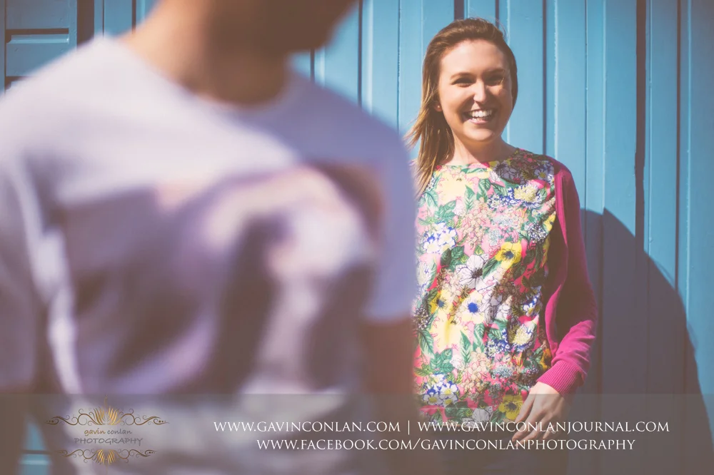 creative fine art portrait of Victoria in front of a blue beach hut at Boscombe Pier . Victoria and James Engagement Session in Bournemouth, Dorset by gavin conlan photography Ltd