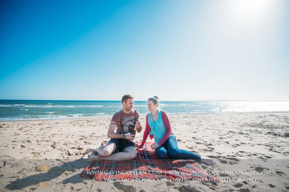 creative portrait of Victoria and James sitting on the beach near Boscombe Pier having fun. Engagement Session in Bournemouth, Dorset by gavin conlan photography Ltd