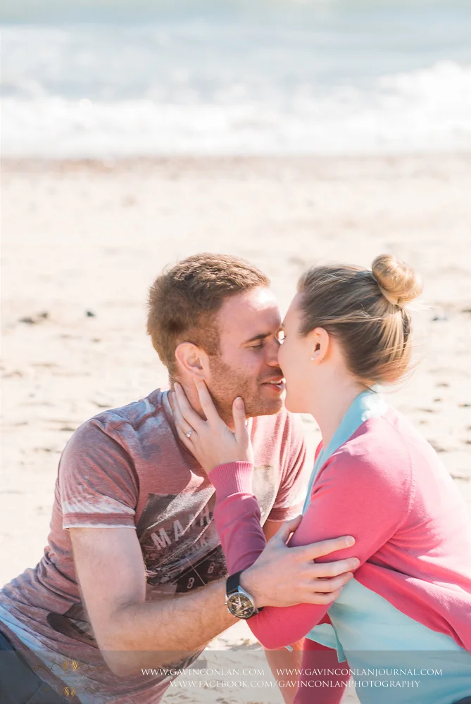 portrait of Victoria and James sitting on the beach near Boscombe Pier about to share a kiss. Engagement Session in Bournemouth, Dorset by gavin conlan photography Ltd