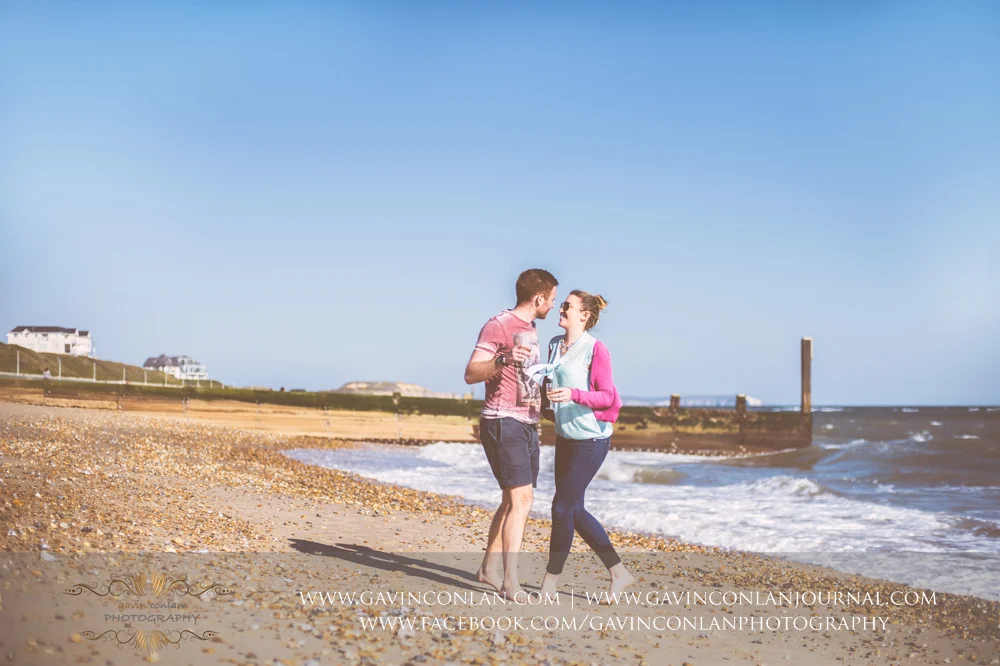 creative fun portrait of Victoria and James on the beach near Boscombe Pier . Engagement Session in Bournemouth, Dorset by gavin conlan photography Ltd