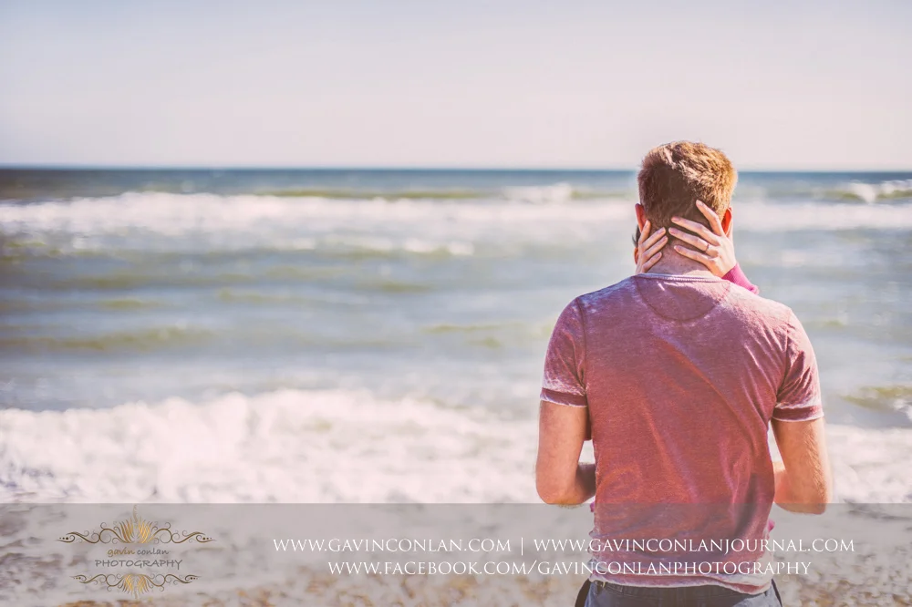 creative portrait showcasing Victoria's hand around the back of James's head on the beach near Boscombe Pier . Engagement Session in Bournemouth, Dorset by gavin conlan photography Ltd