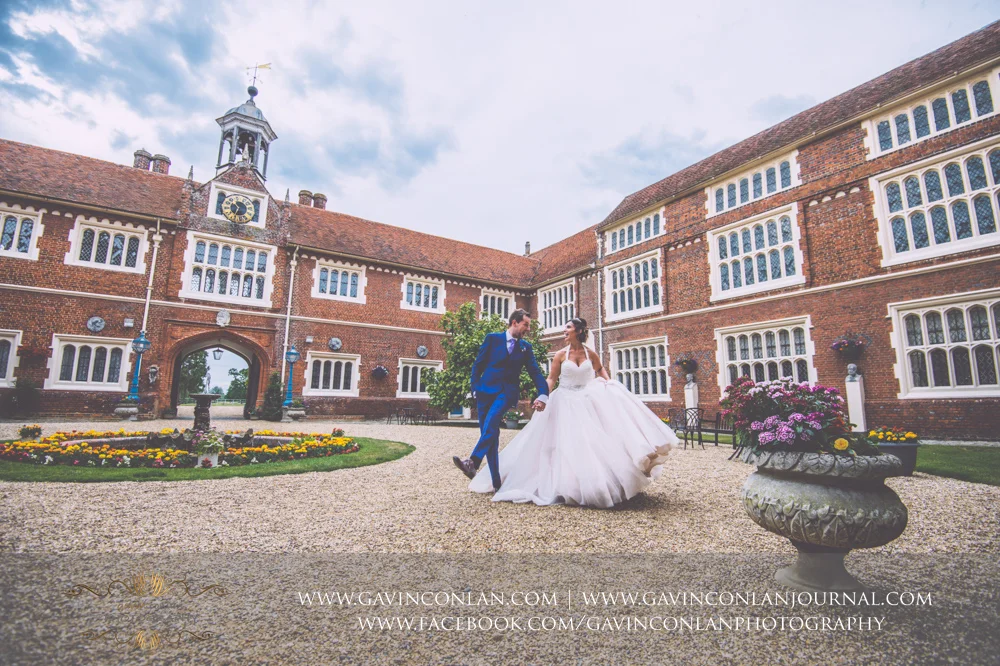 creative and fun portrait of the bride and groom in the inner courtyard of Gosfield Hall. Wedding photography at Gosfield Hall by Essex wedding photographer gavin conlan photography Ltd