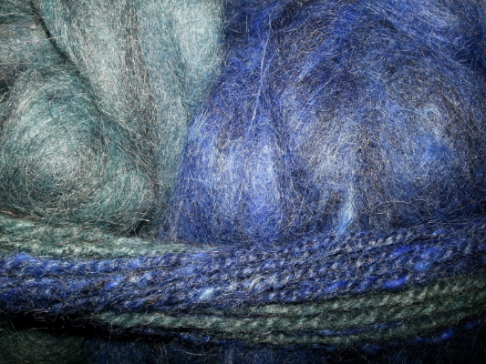 Cobalt and teal angora and merino blend. I spun a sample of self-striping yarn which you see around it.
