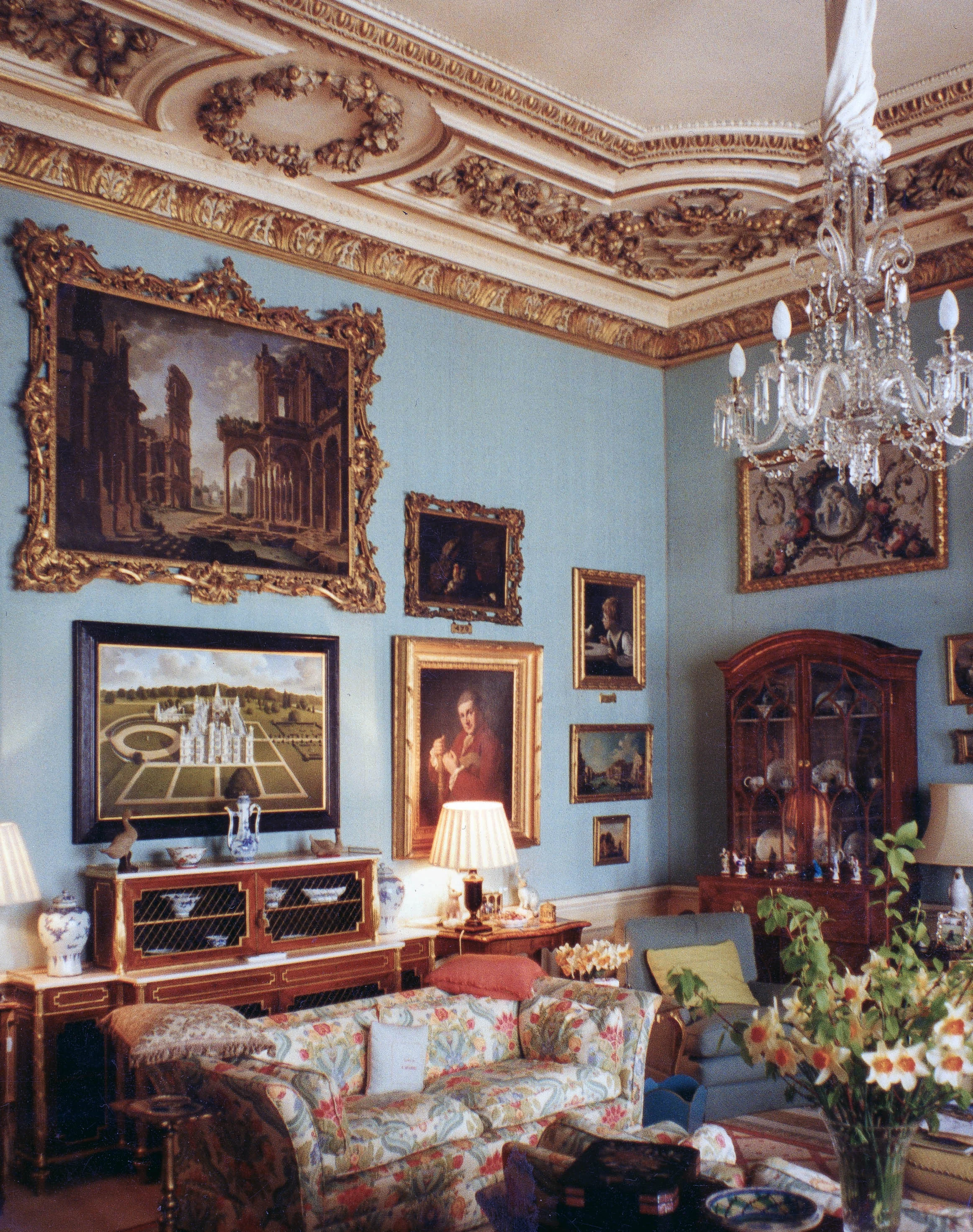 One of Jonathan Myles-Lea's paintings of Burghley hanging in the Blue Sitting Room inside the house. Above the painting hangs a capriccio by Giovanni Paolo Pannini and to the right is Angelica Kaufman's self-portrait.