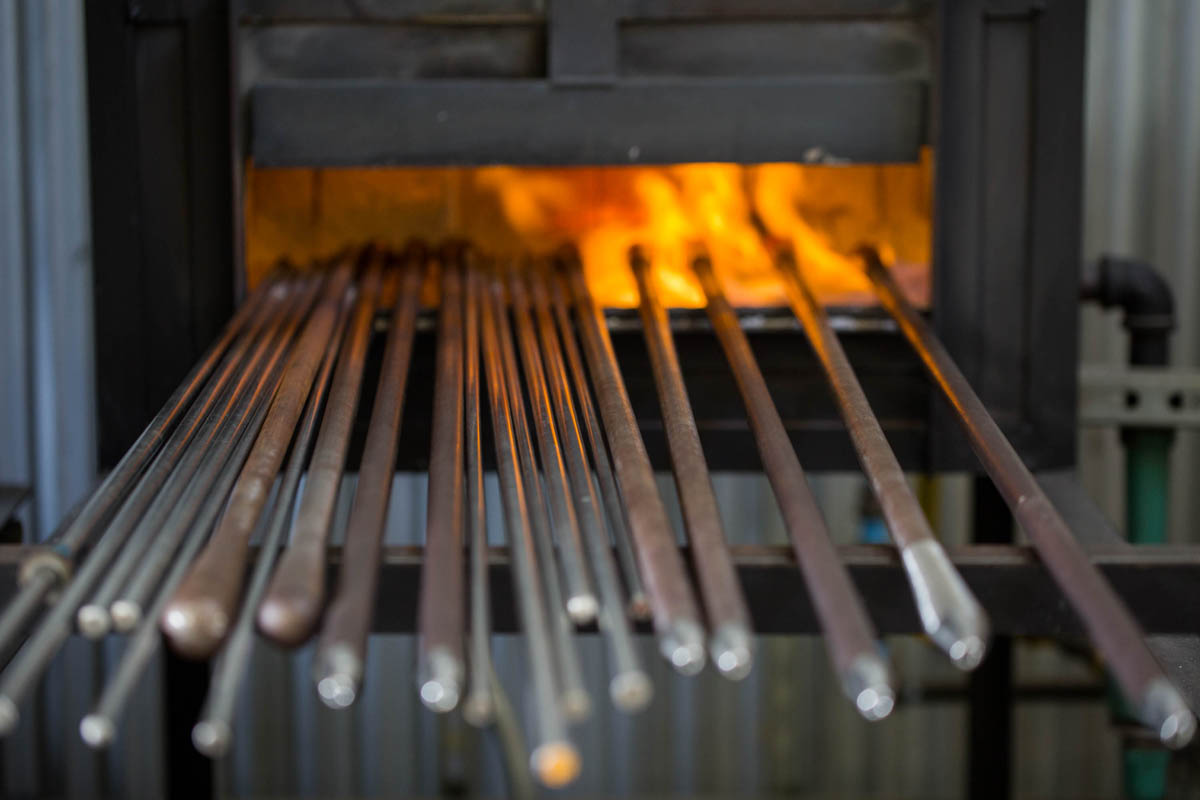 Preheating steel blowpipes we'll use to shape the glasses