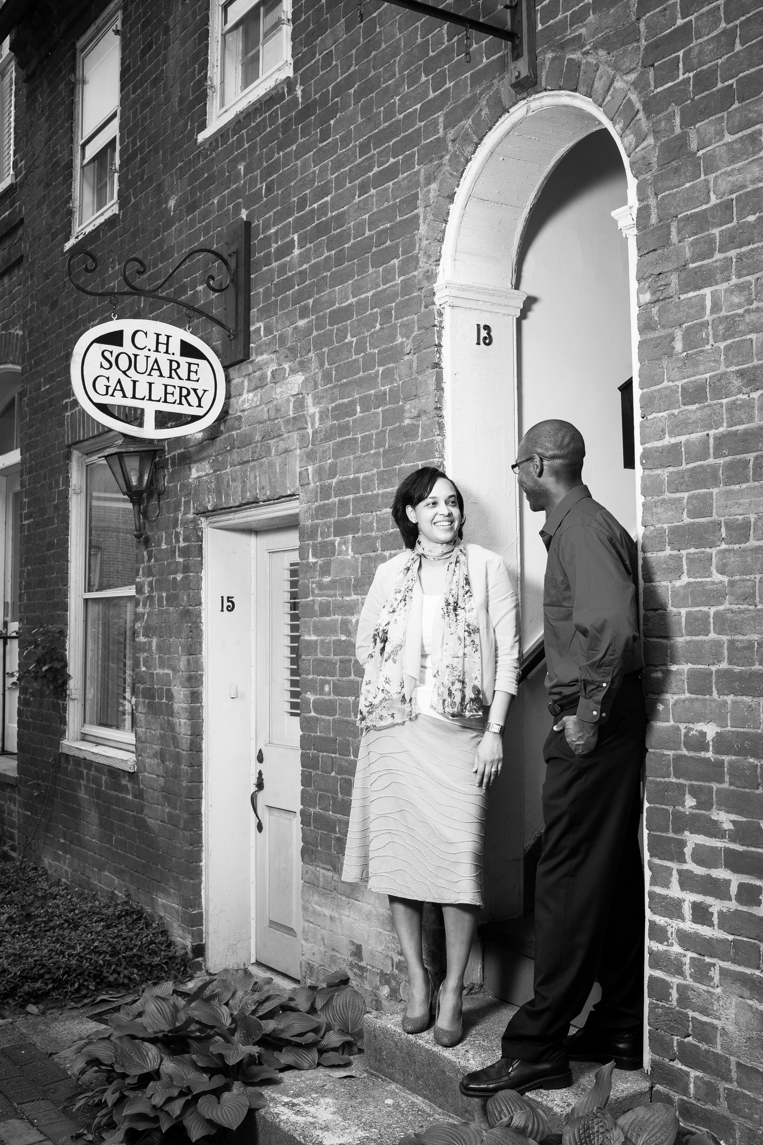 Black and white engaged couple in front of brick